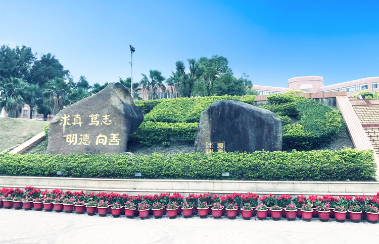 厦门英才学校景观石刻校训求真笃志明达至善，绿植花卉环绕，校园文化环境建设