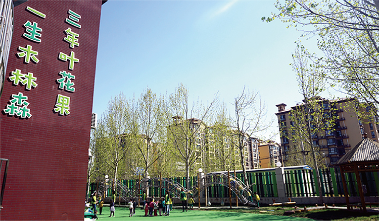 北部新区实验幼儿园园所建筑实景,红墙三年叶花果一生木林森字样与操场,校园文化