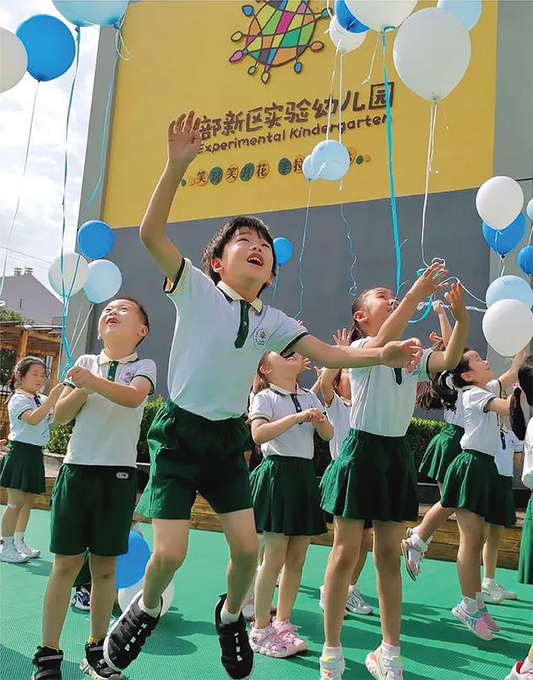 北部新区实验幼儿园孩子们身着绿白园服持气球活动照片，园所文化活动场景