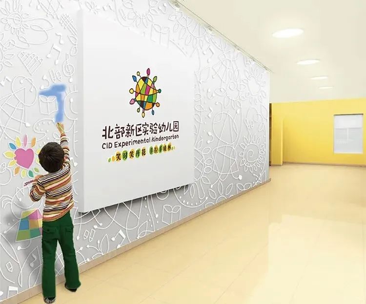 北部新区实验幼儿园门厅实景，白色肌理墙配园徽与孩子手绘，文化环境建设