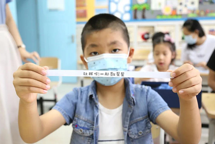 灯市口小学男孩手持星际通行证纸条的照片,星空主题文创应用场景