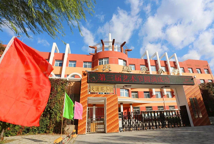 灯市口小学校门实景照片，红色教学楼配红色装饰，校园特色定位形象展示