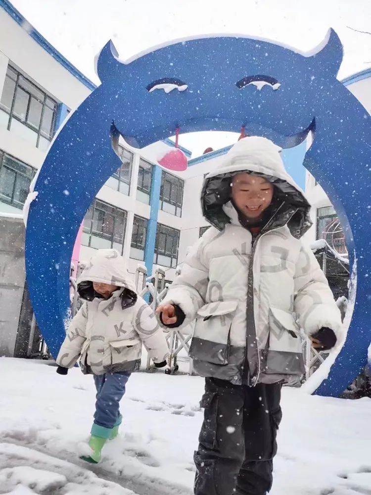中科大幼儿园门口蓝色卡通造型景观雕塑,雪天孩子入园,校园环境文化建设
