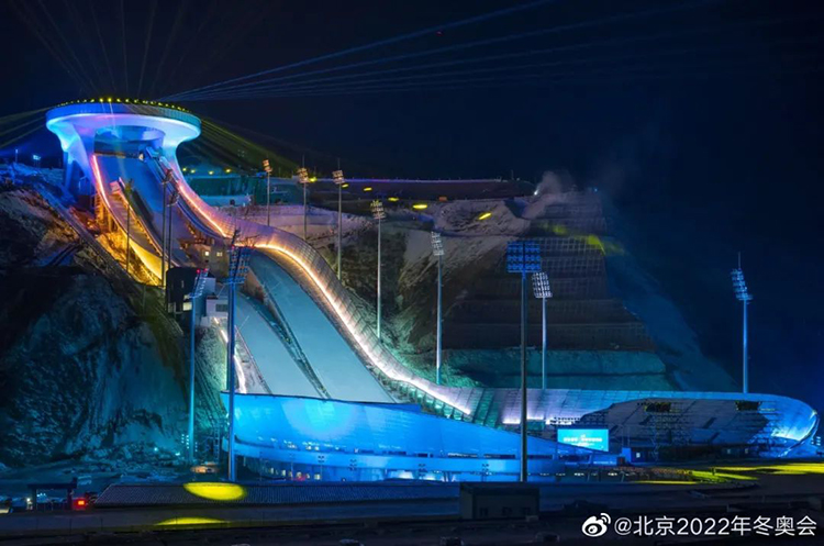 首钢滑雪大跳台“雪飞天”夜景,蓝色灯光照亮跳台曲线造型