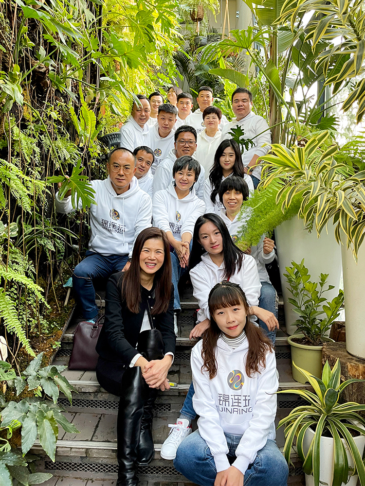 锦连环团队身着白衣在绿植墙前合影留念，2021文化之旅