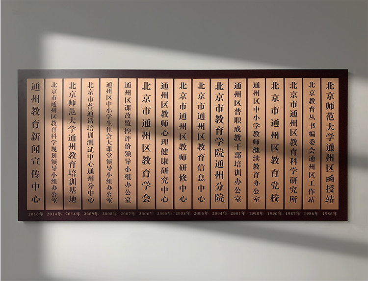 通州区教师研修中心荣誉牌匾墙,多块教育机构木质挂牌排列,体现深厚学术积淀