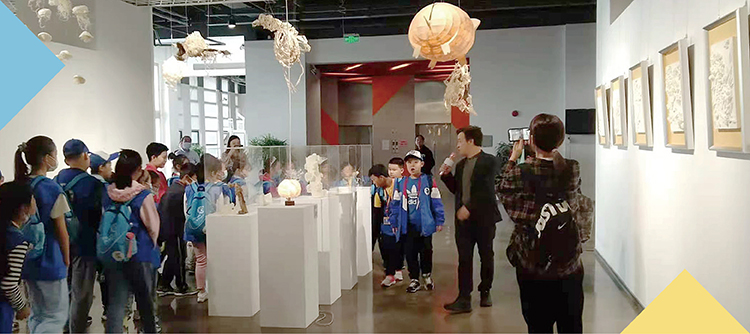 展厅悬挂鱼形纸艺灯饰装置观众参观，锦连环校园文化纸艺展现场