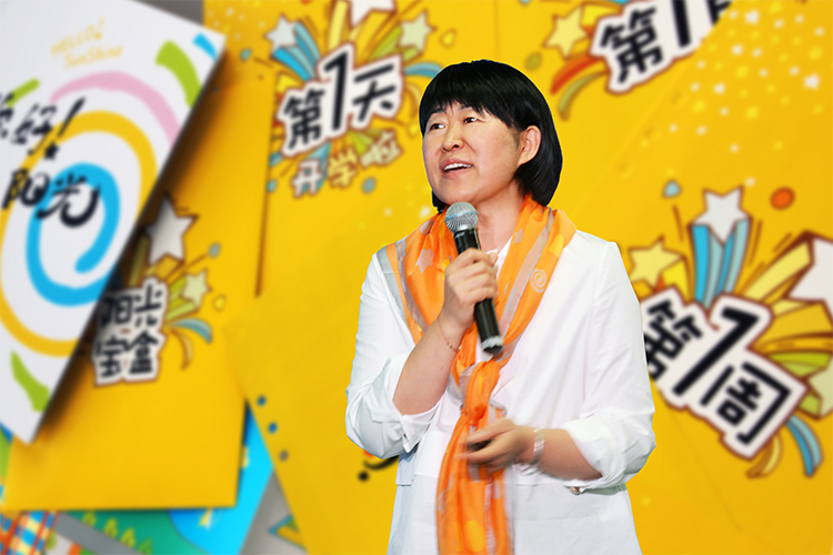 女性嘉宾在彩色舞台手持话筒演讲,2020中国教育报校长大会现场