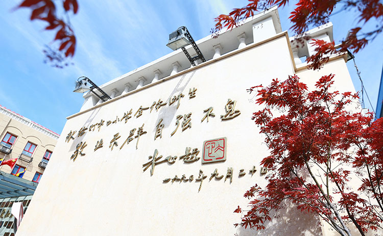 灯市口小学校园外墙题字与红枫实景，呼应百年老校文化