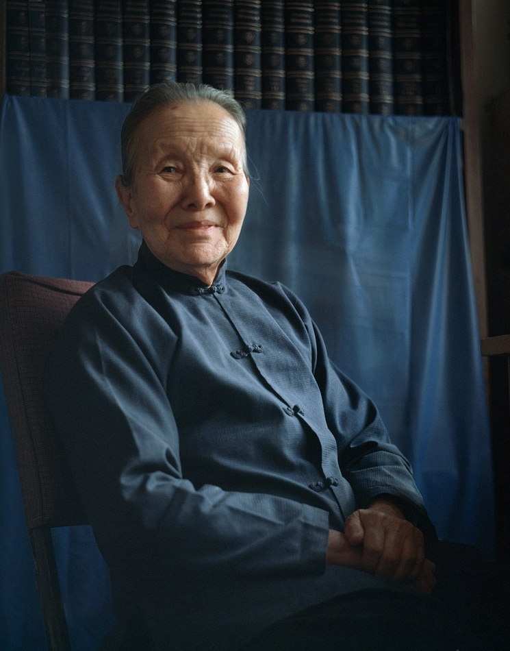 灯市口小学历史人物深色中式服装肖像，呼应百年老校历史传承