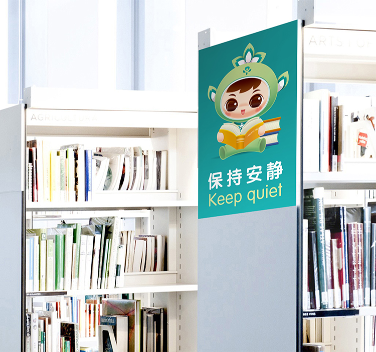北医附小图书馆书架旁摆放吉祥物立牌,吉祥物IP形象融入校园阅读空间应用