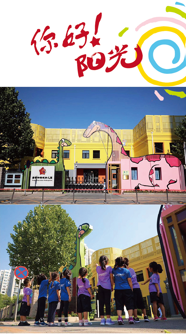 北京市海淀区唐家岭新城幼儿园黄色园舍大门,两只高大恐龙造型雕塑,孩子们仰望,校园文化环境建设实景