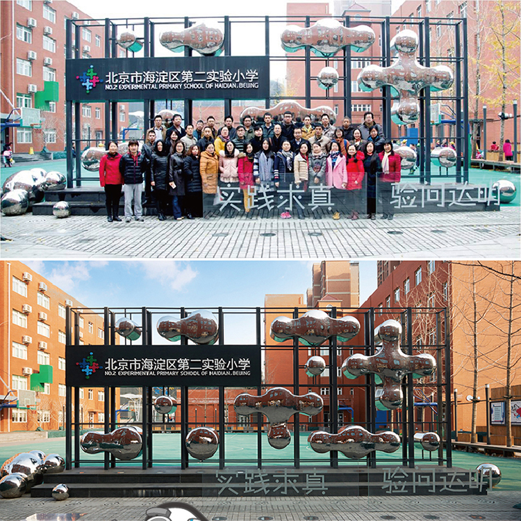 北京市海淀区第二实验小学教学楼外景,悬挂师生合影与品牌辅助图形的校园文化墙