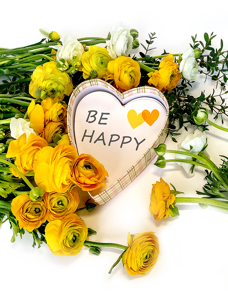 黄色洋牡丹与白色花朵环绕'BE HAPPY'爱心牌的花艺摆设,'一抹金黄'主题暖意配图
