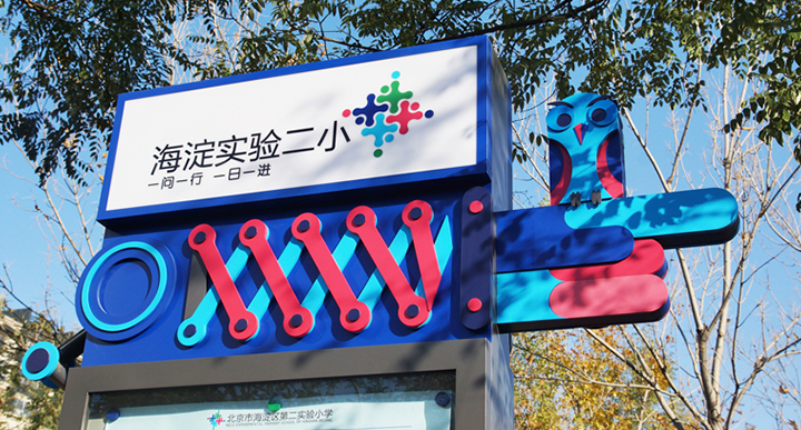 海淀区实验二小校门口导视门头实景，红色立体招牌与校园品牌视觉设计