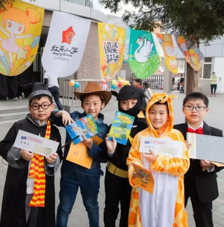 红英小学学生身穿七彩阳光战袍手持品牌物料，校园活动展现阳光岛文化