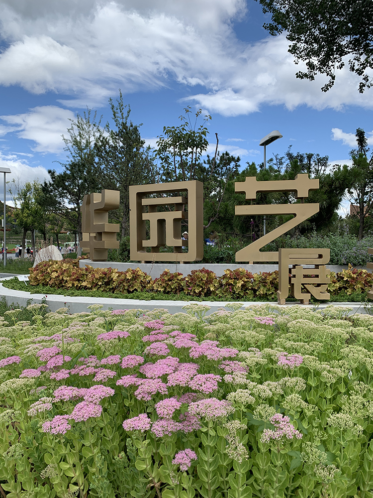 世园会绿植造型景墙与前景粉色绣球花，植物拼字造景，呼应园艺展主题