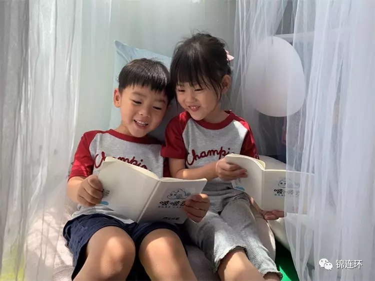两名孩子依偎共读绘本，展现温馨的亲子阅读与情绪陪伴场景