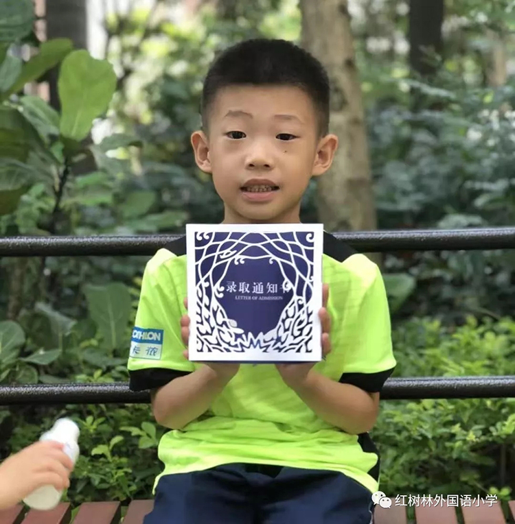 一名男孩在户外手捧红树林蓝色镂空录取通知书