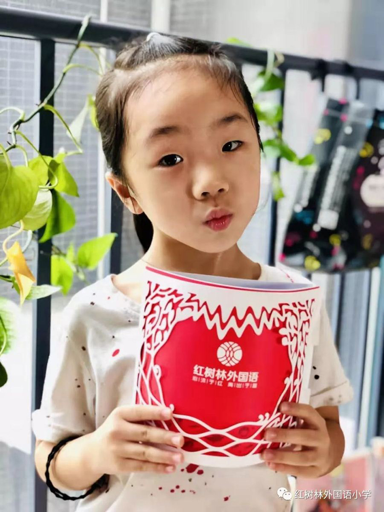 一名女孩双手捧着红树林红色录取通知书开心展示