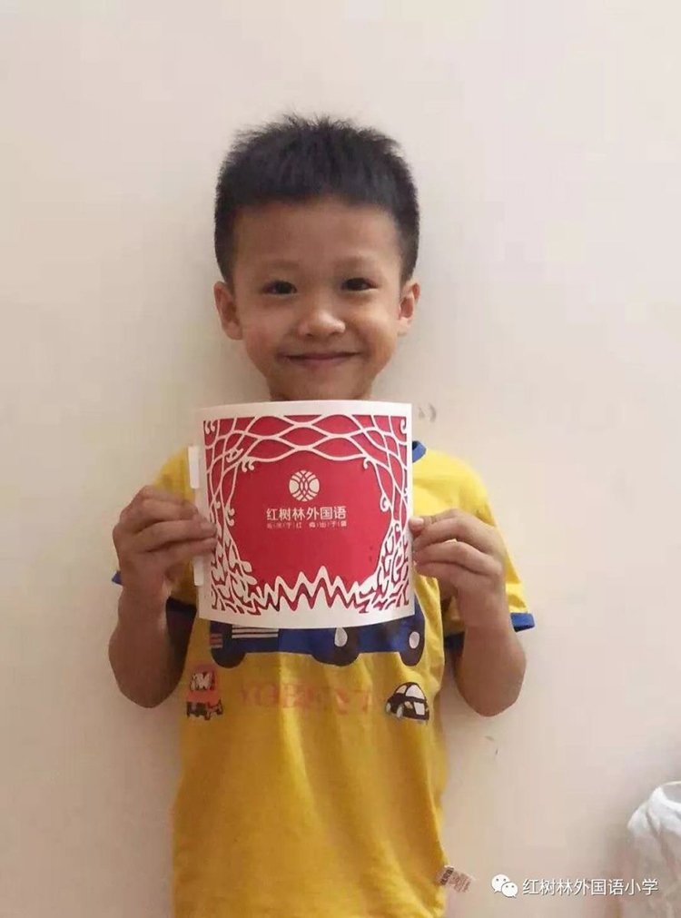 一名男孩手捧红树林外国语小学录取通知书在室内开心留影