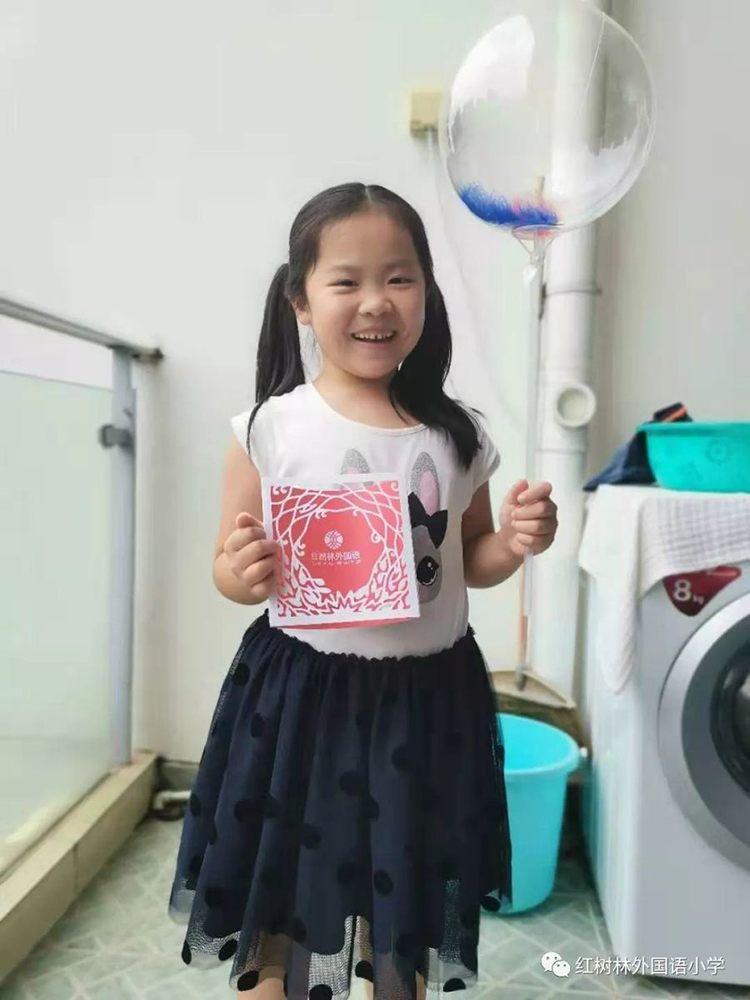 一名女孩在家中手持红树林红色录取通知书拍照展示