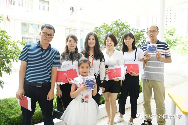 一家人手持红树林外国语小学录取通知书的温馨家庭合影