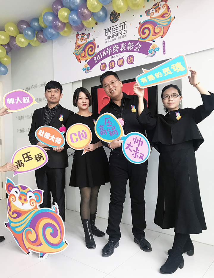 锦连环员工在2018年终表彰大会气球背景墙前手持创意道具欢乐合影