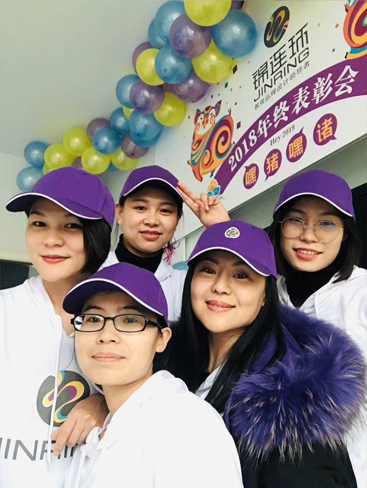 锦连环2018年终表彰大会上女员工头戴紫色装饰帽在气球背景墙前合影