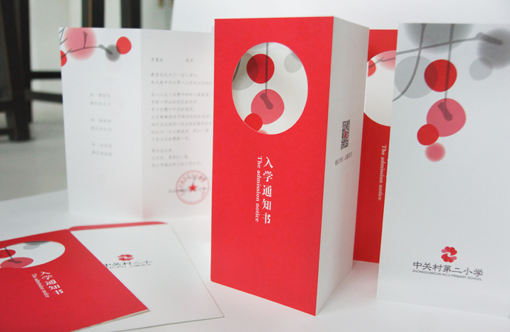 红色入学通知书展开呈现圆形镂空创意设计,层叠折页传递喜庆精致的校园品牌质感