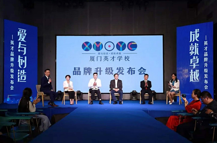 厦门英才学校品牌升级发布会舞台全景，背景板印有爱与创造成就卓越主题，呈现教育品牌设计风采