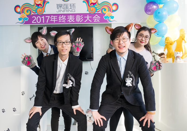 锦连环员工身着正装合影欢呼，彩纸纷飞，定格年终表彰大会的欢乐瞬间
