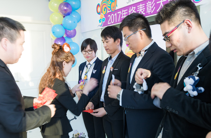 锦连环员工怀抱小狗玩偶互动交流，呼应狗年年终表彰大会的萌趣主题