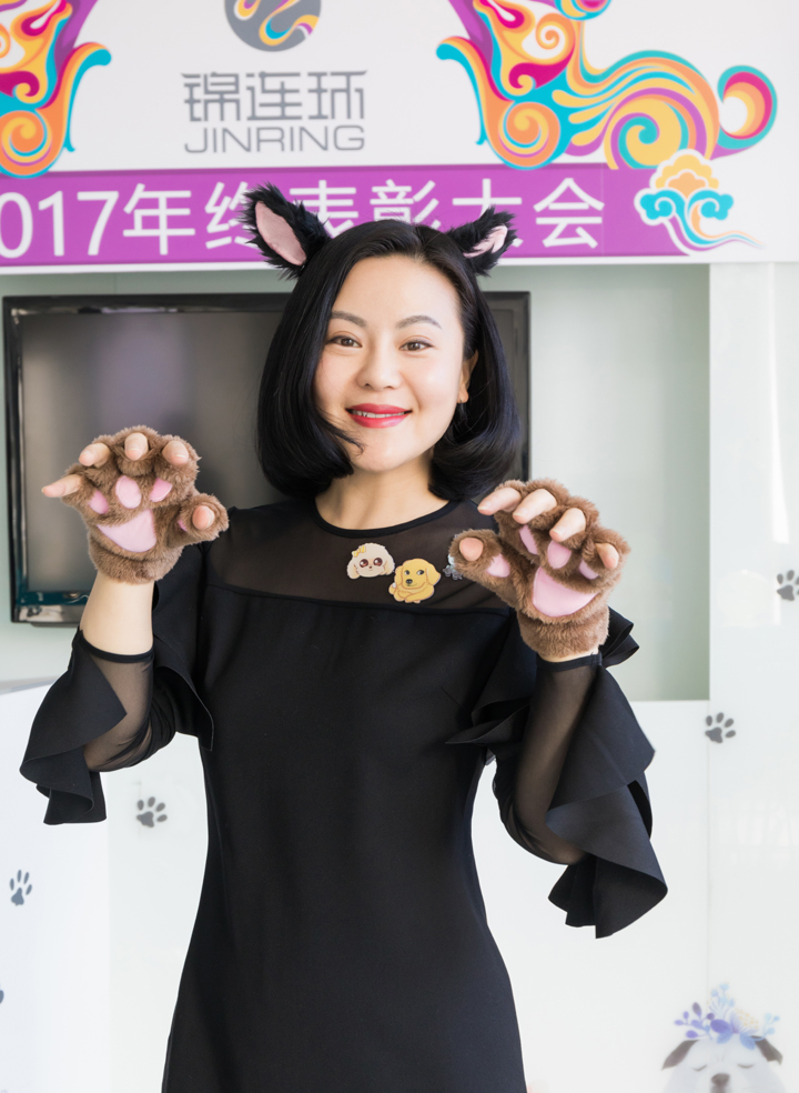 锦连环女员工头戴狗耳装饰做爪子手势，背景为2017年终表彰大会主题板