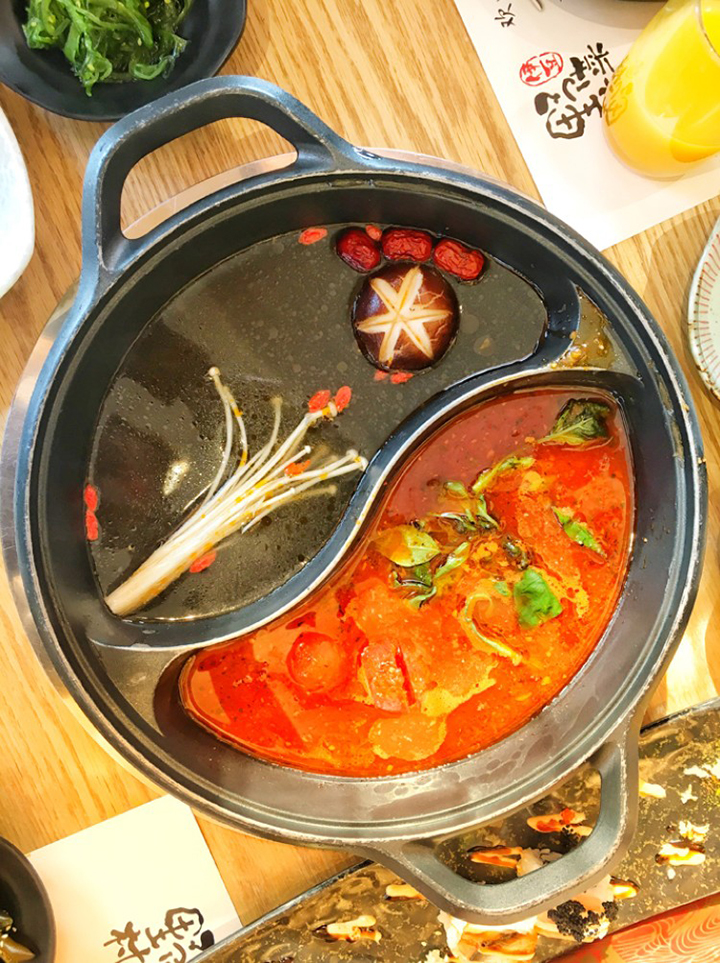 红汤火锅锅底特写热气腾腾，烘托锦连环团队聚餐的暖意