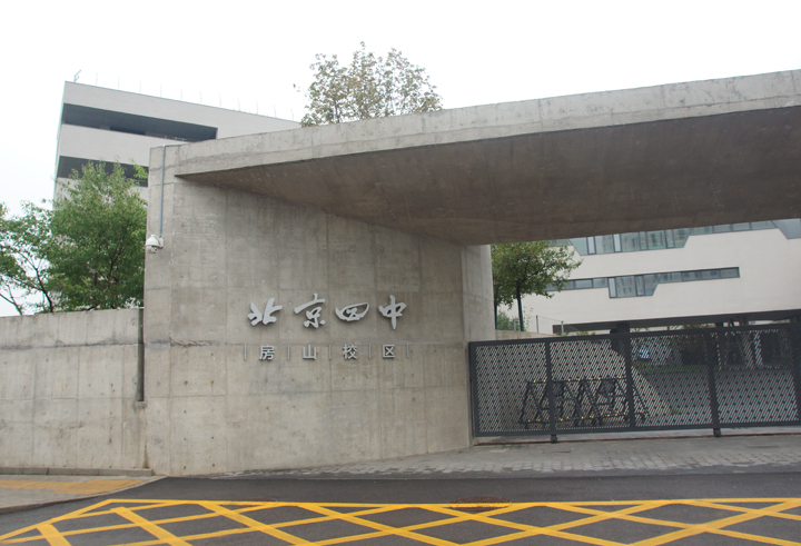 北京四中房山校区清水混凝土入口外景,墙面镌刻北京四中标识,体现学校文化建设简约自然的风格