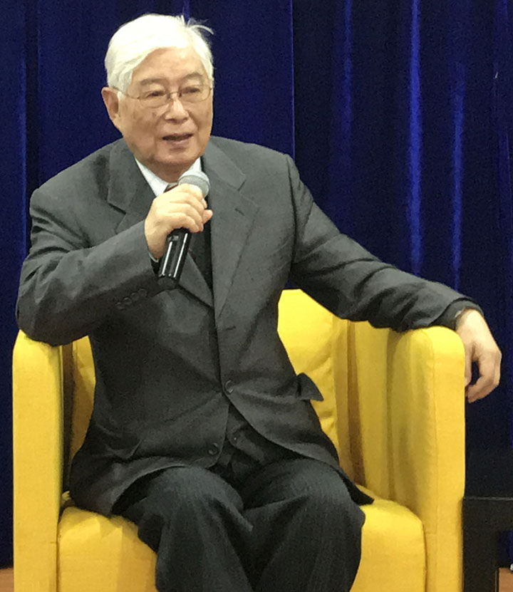 北京师范大学教授顾明远在中美教育对话论坛上手持话筒发言的现场画面