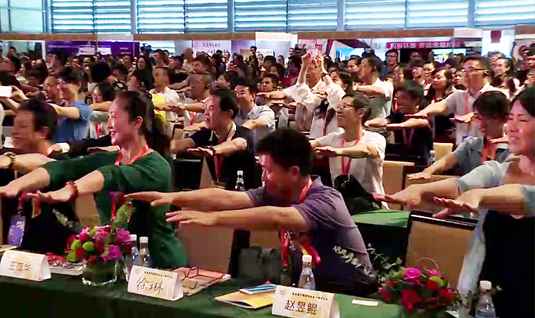 积极心理学大会现场观众踊跃伸手参与互动体验环节