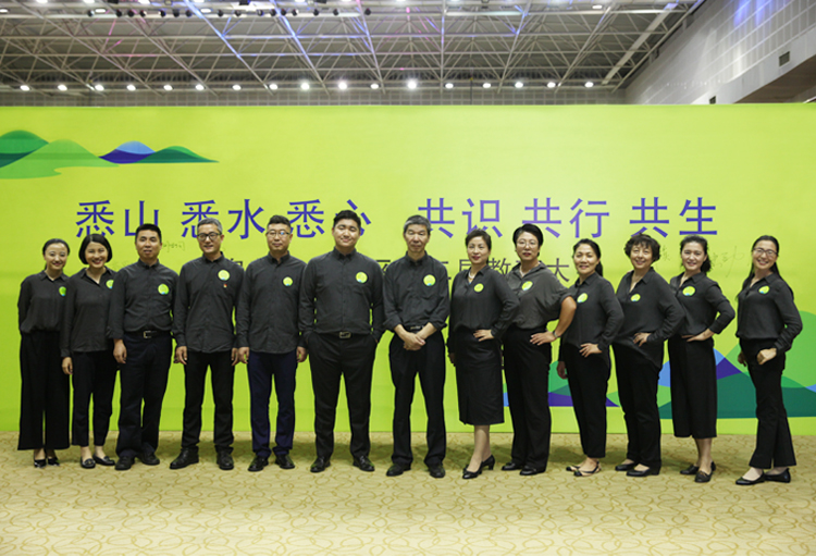 温泉苏家坨教育大会教师身着深色服装登台合影,背景大屏展示大会主题标语