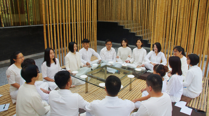 锦连环小伙伴身着白衣围坐竹屋中交流分享，感受建筑与文化之美