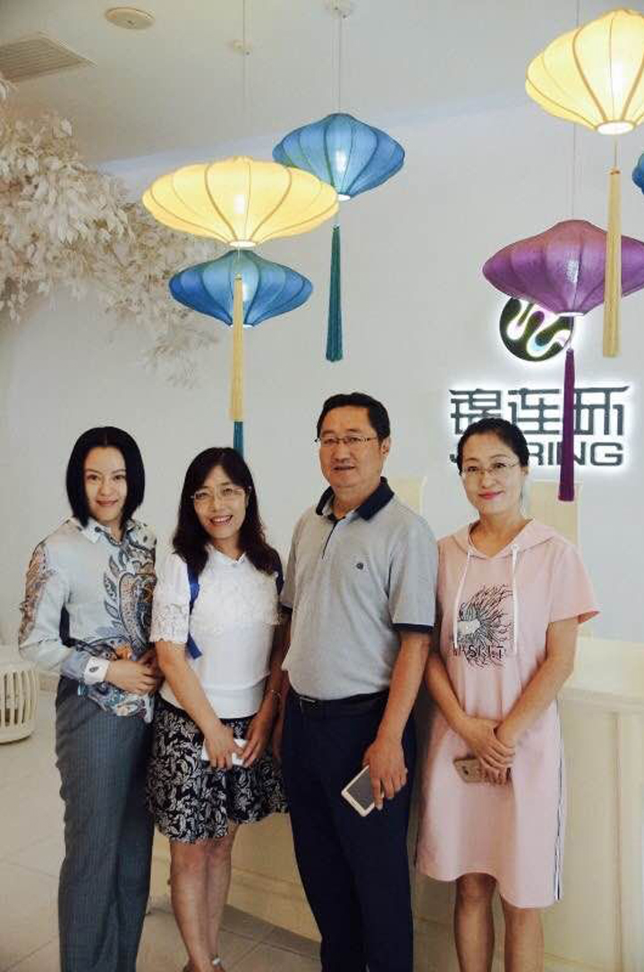 锦连环团队成员与兰州华侨实验学校教师在校园室内合影,开展品牌调研