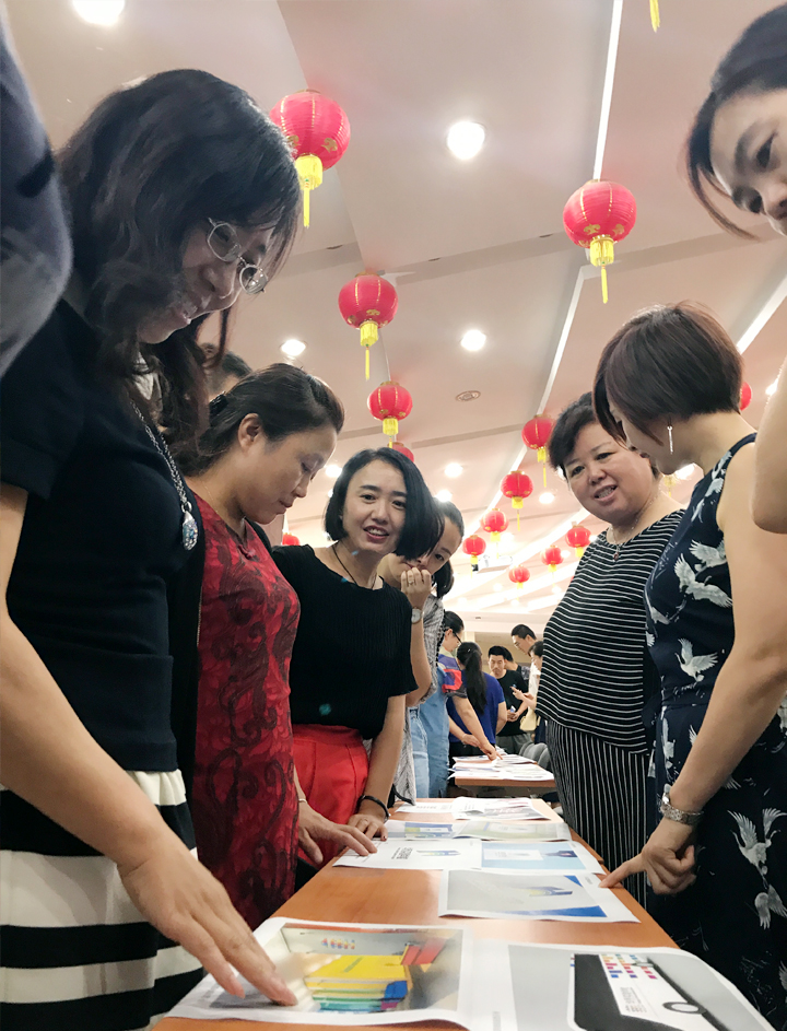 兰州华侨实验学校教师围坐桌前交流互动,参与品牌文化主题活动