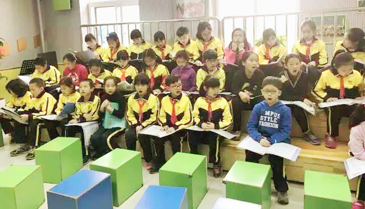北京石油附小学生身着校服佩戴红领巾在教室齐读书本,校园学习场景