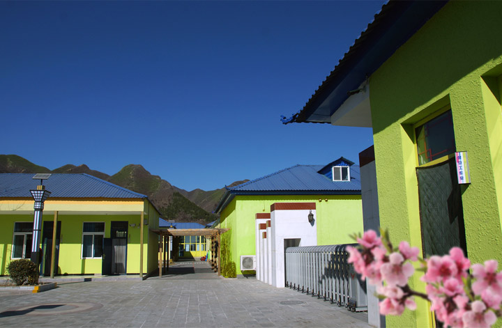 昌平区桃洼学校校园建筑外景照片，彩色墙面教学楼与远山构成校园环境