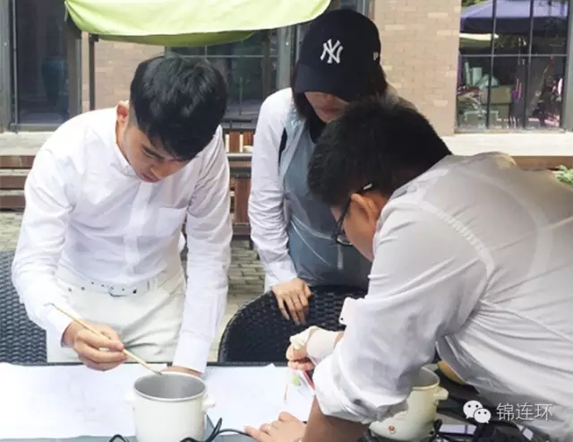 锦连环团队成员围坐设计捆扎扎染图案场景，文化之旅手工体验活动，企业团队文化建设