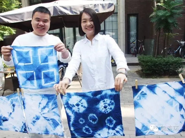 锦连环团队成员在户外展示蓝白扎染作品，文化之旅手工体验活动成果留念