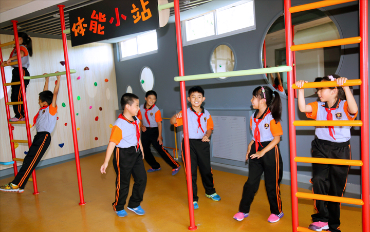 石油二小室内活动空间,学生在书架墙前排队,锦连环校园文化建设案例