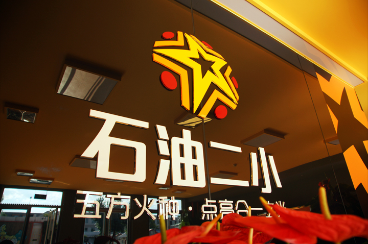 石油二小品牌墙设计,黑底金色星形logo与星火理念语,锦连环教育品牌设计