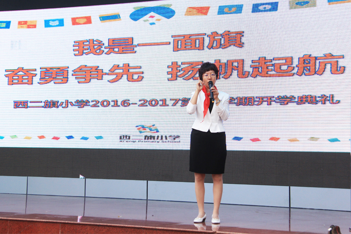 西二旗小学开学典礼主持现场,LED屏显示我是一面旗主题,锦连环旗趣文化教育品牌设计展现