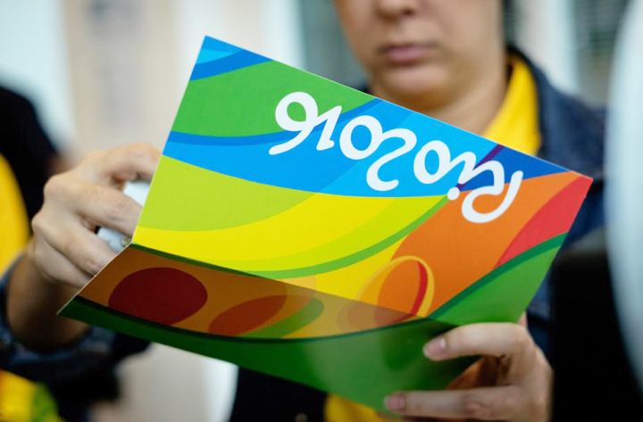 里约奥运会品牌宣传物料，手持彩色波浪纹样折页，VI系统宣传应用设计展示